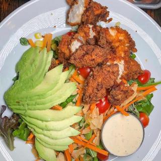 The Austin Salad 🥗 crumbled corn tortilla chips, shaved red onions, carrots, grapes tomatoes, corn, avocado over mixed greens with your choice of grilled or fried (here!) chicken. Recommended with habanero ranch dressing 👍